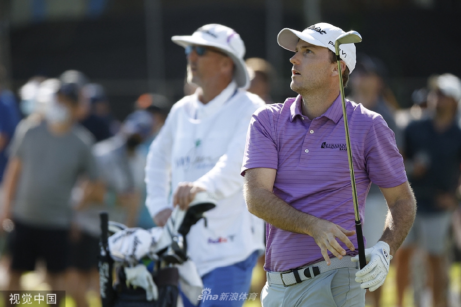 松山英树与球童在决赛轮关键洞仔细研究码数本和风向，进行最后的战术确认。