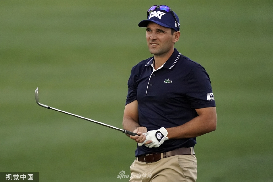 里奇·福勒在果岭上俯身进行推杆前的最后校准，他标志性的鲜艳着装与果岭的翠绿形成鲜明对比，气氛紧张而安静。