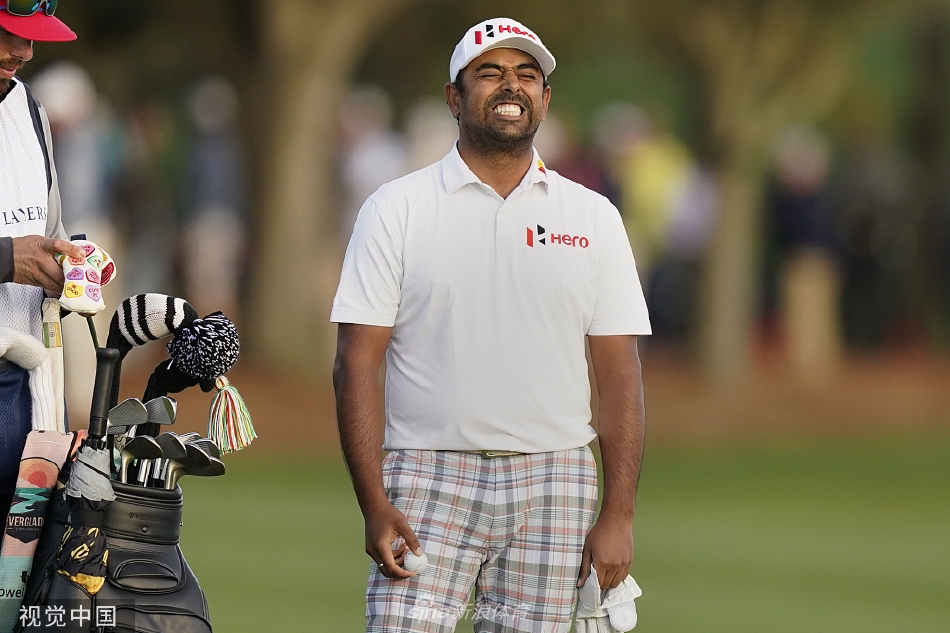 阿尼班·拉西里在第十八洞果岭上遗憾地望向远方，眼神中交织着失落与坚毅，身旁的球童试图给予安慰。