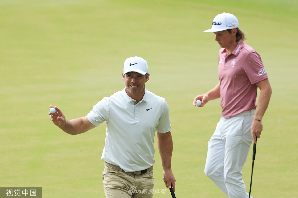 保罗·卡西在果岭上微笑着与史密斯握手致意，展现出球员之间的崇高 sportsmanship 与互相尊重。