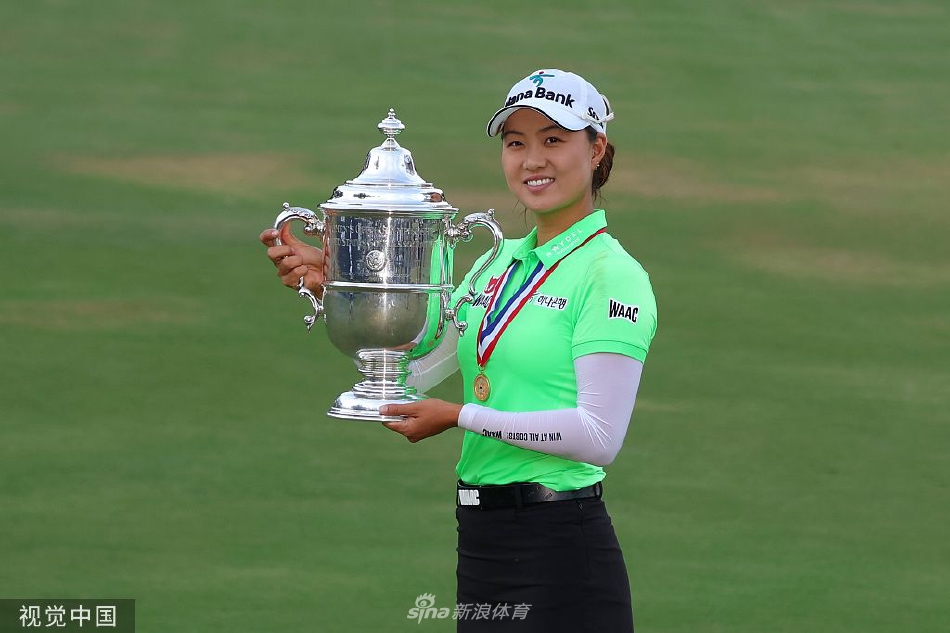 李旻智在第十八洞果岭推入制胜一推后，激动地高举双臂，脸上绽放出灿烂的笑容，身后是欢呼的观众与经典的赛事标识。