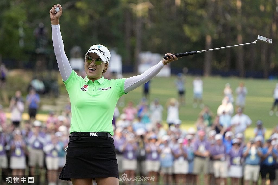 林希妤在球道上全神贯注地准备挥杆，阳光洒在她坚定的侧脸上，背景是开阔而富有挑战性的锦标赛球场。