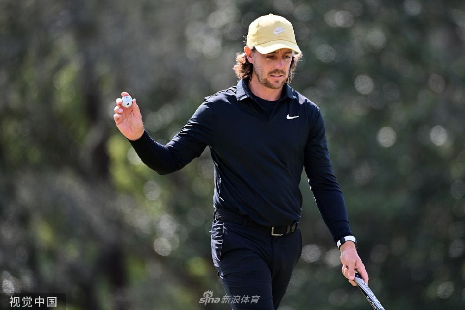 摩尔与球童在决赛轮中认真研判球场风向与果岭起伏，讨论关键一击的策略