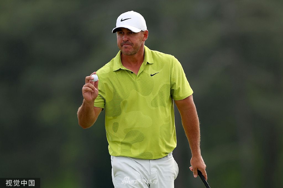 琼·拉姆在开球后沉稳地目送小白球飞向球道，动作流畅充满力量，奥古斯塔标志性的球道与树林构成经典的赛场画卷