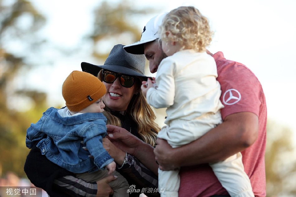 拉姆与妻子在奥古斯塔会标前甜蜜合影，共同分享人生中的重要荣耀