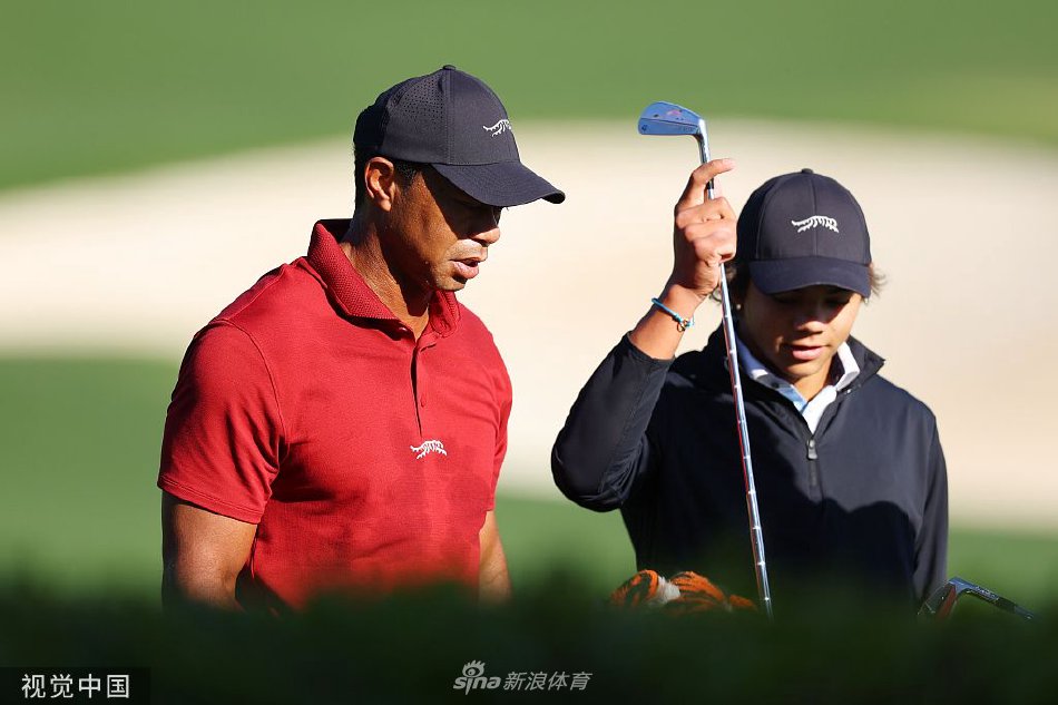 伍兹挥杆瞬间,身体如紧绷的弓,凝聚着全部力量与毕生技艺,背景是奥古斯塔著名的观众看台