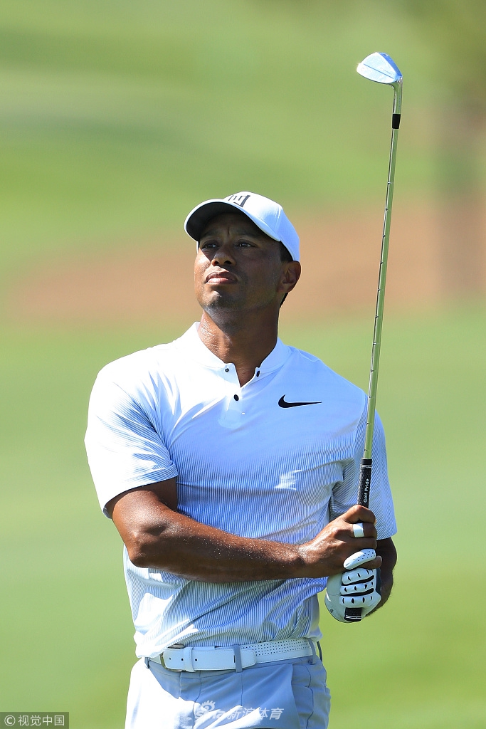 夕阳下老虎伍兹背对镜头走向会所，身影在锯齿草球场上拉长，留下坚定而充满希望的背影