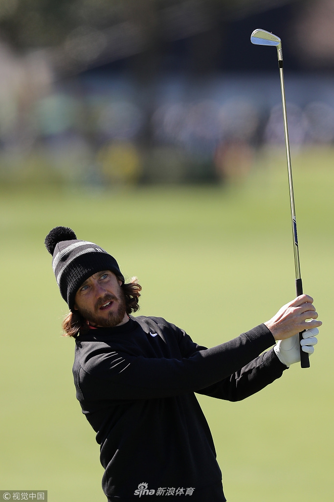 贾斯汀·罗斯在果岭上俯身仔细观察推杆线路，神情无比专注