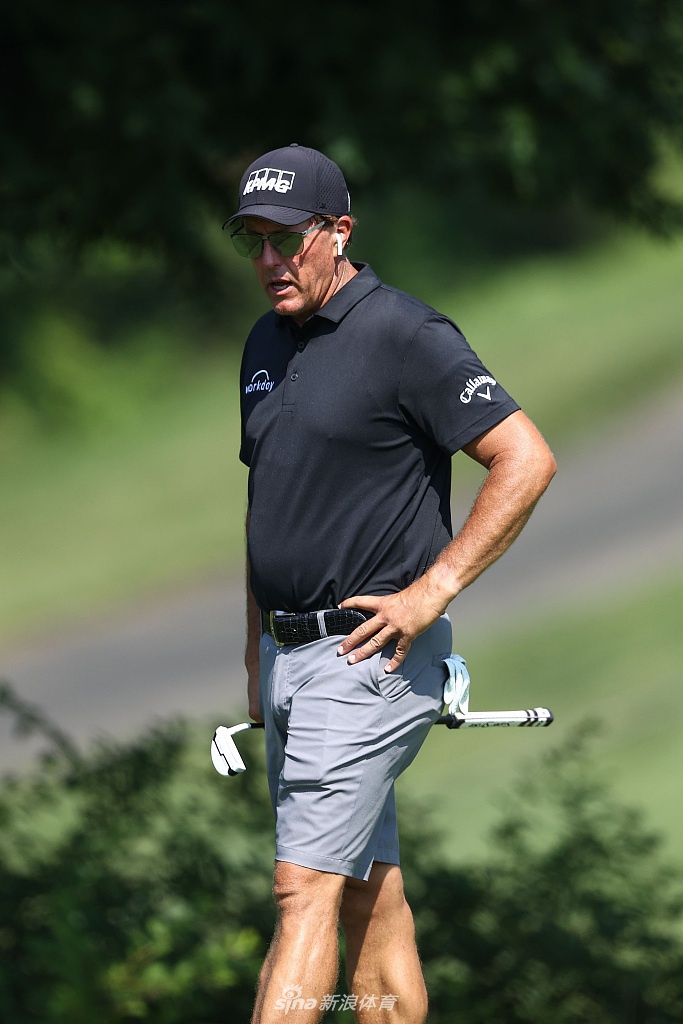 松山英树正在沙坑中练习救球,扬起一片金黄色的沙雾,神情沉着坚定