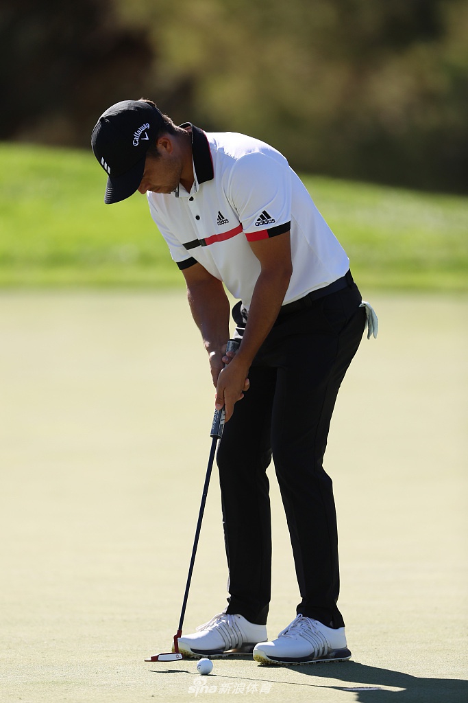 罗里·麦克罗伊在发球台上全力挥杆，肌肉线条紧绷，身体扭转充满力量感，高尔夫球在空中划出一道优美的弧线。