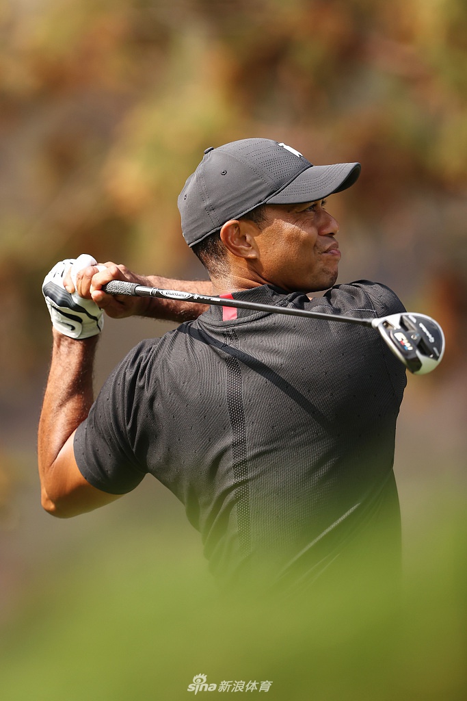 近距离特写伍兹的侧面，他戴着标志性的帽子，眼神锐利地望向果岭方向，下颌线紧绷。