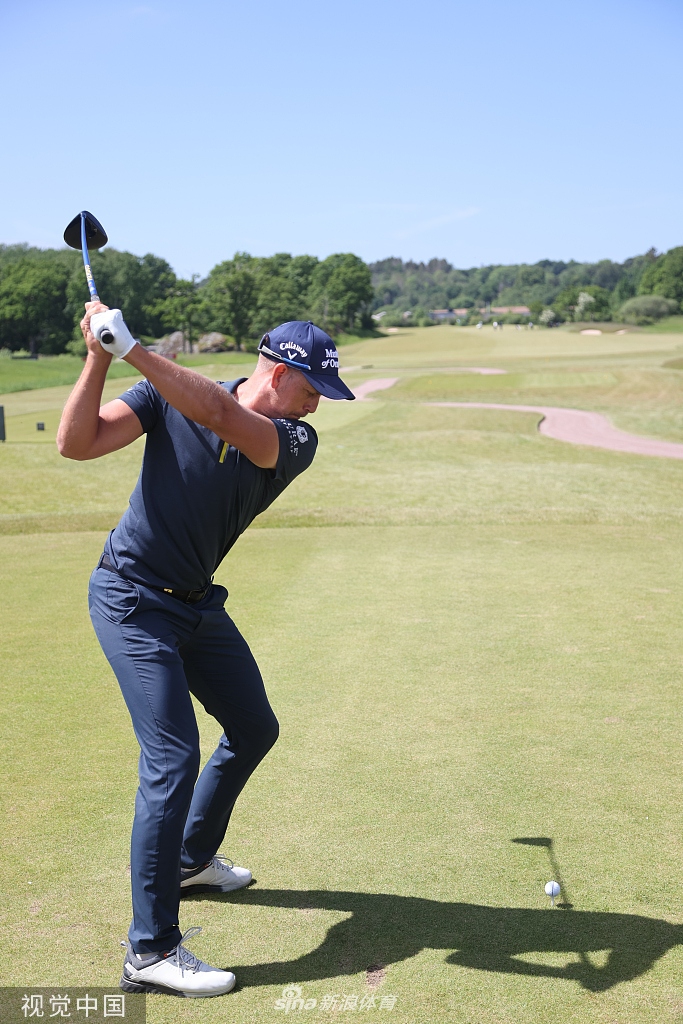 斯滕森与儿子卡尔并肩走在球道上，卡尔认真地观看着父亲的准备，父子间的交流充满默契与温情。