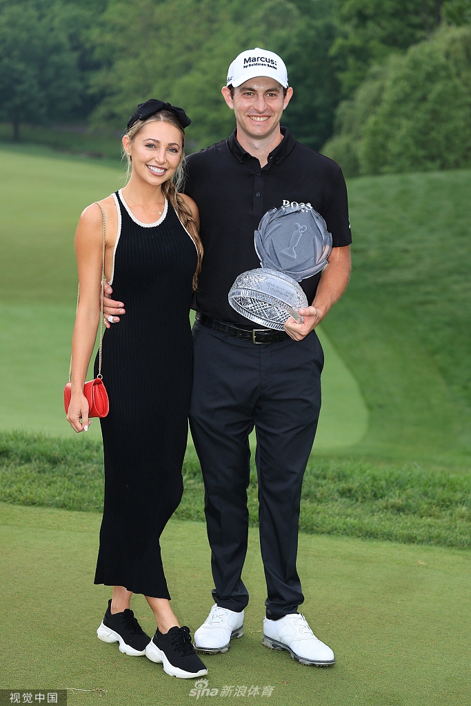 妮基亲密地搂住坎特利，两人手持奖杯，脸上洋溢着同步的幸福笑容。