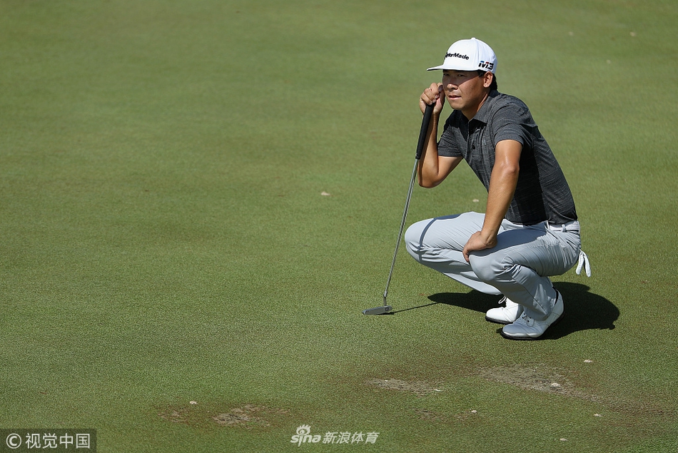 张新军凝神审视球道线路，目光如炬分析果岭起伏与风向