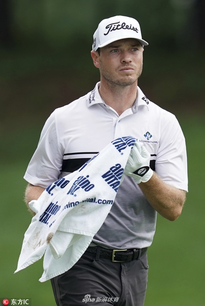 山姆桑德斯在比赛中面对一记关键的果岭边切杆，他蹲下身仔细研究草纹与地形，思考最佳击球方案。