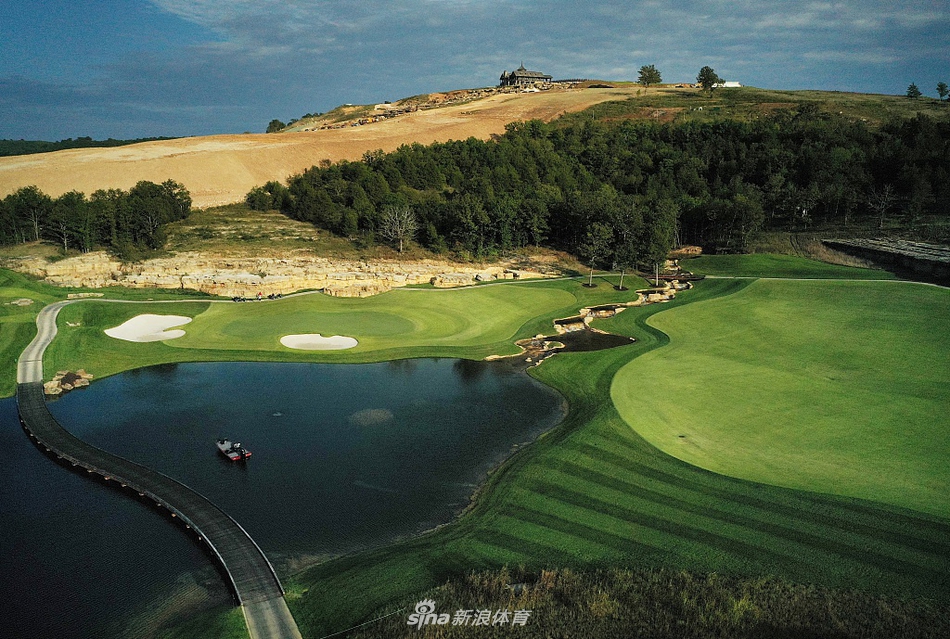 阳光洒在起伏的果岭和环绕的沙坑上，形成明暗交错的光影，呈现出顶级球场的质感与细节。