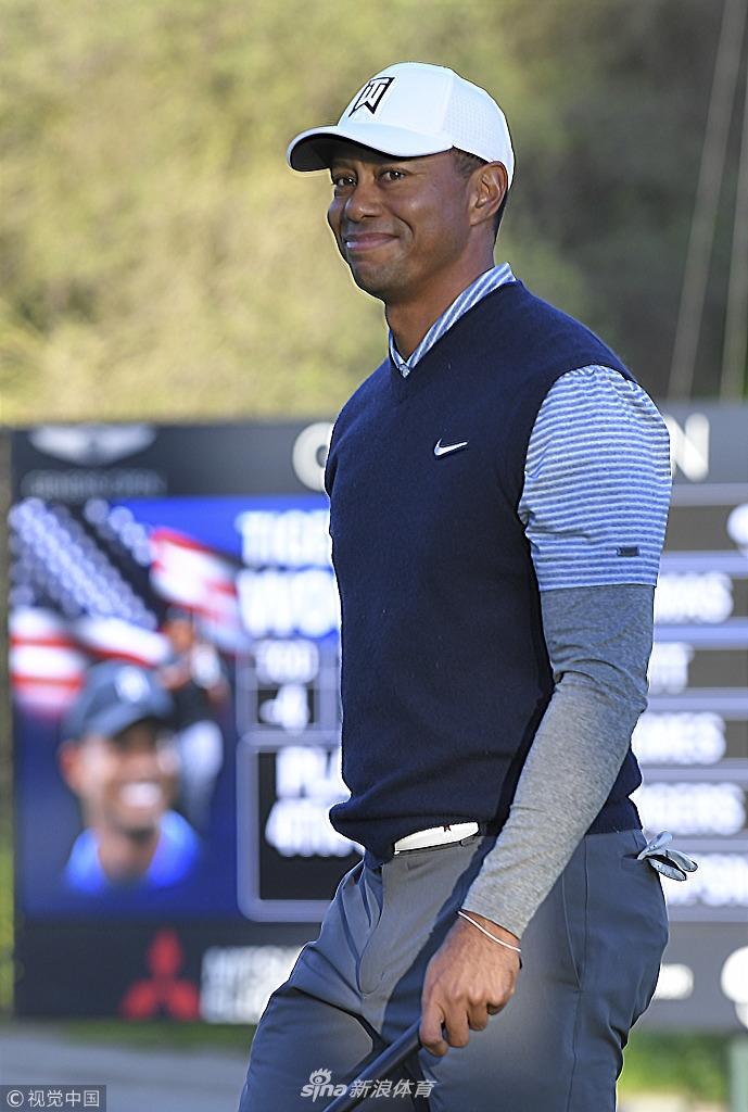 伍兹在第十一洞果岭上推进老鹰推，他紧握拳头振臂庆祝，身后是陷入沸腾的观众。