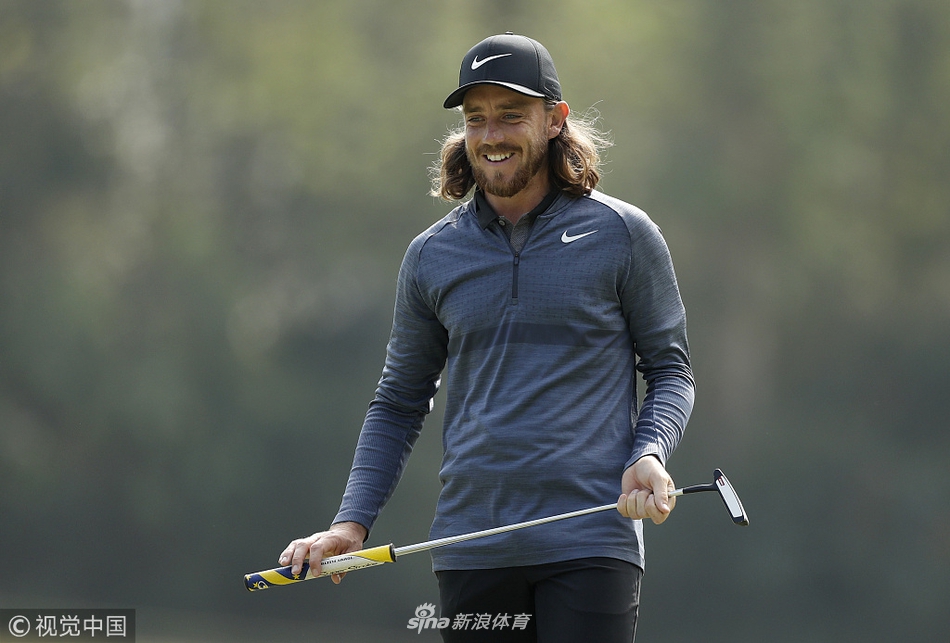 印度选手沙玛全力挥杆，身体舒展形成完美弧线，背景是香港公开赛的标志性景观