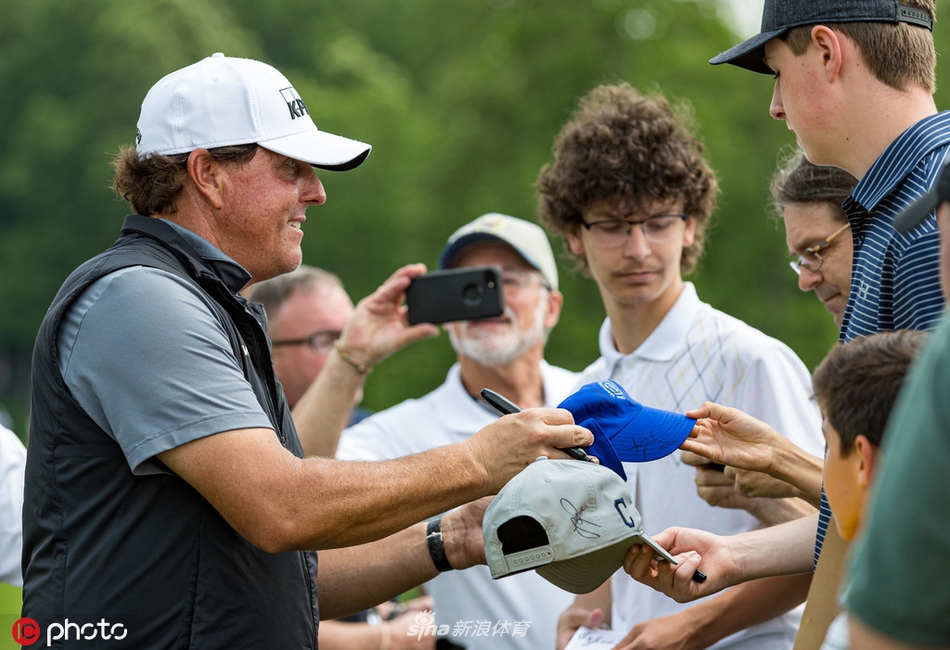 练习日黄昏时分，球员与球童走在洒满金光的球道上，勾勒出一幅充满故事感的美丽剪影