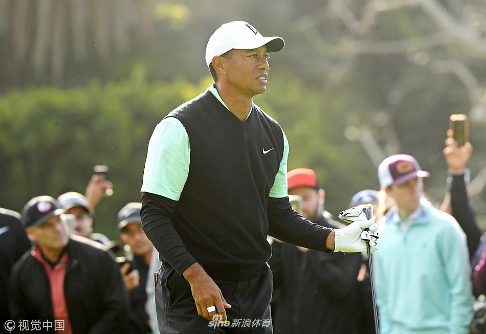 老虎伍兹在走向下一洞发球台时与球童交流,神情专注地商讨比赛策略