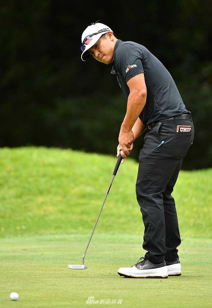 库尔特·北山在球道上仔细观察线路，表情专注，阳光洒在他身上，拉出长长的身影。