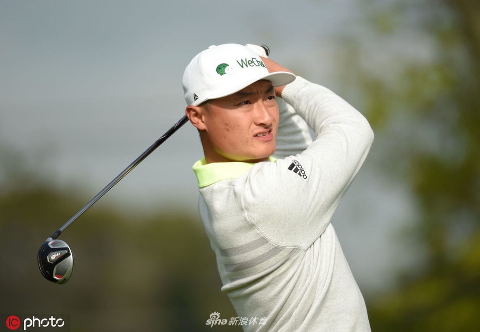 李昊桐漫步于贝斯佩奇黑球场，与球童交流策略，身后是广袤的球场与竞争的序幕。