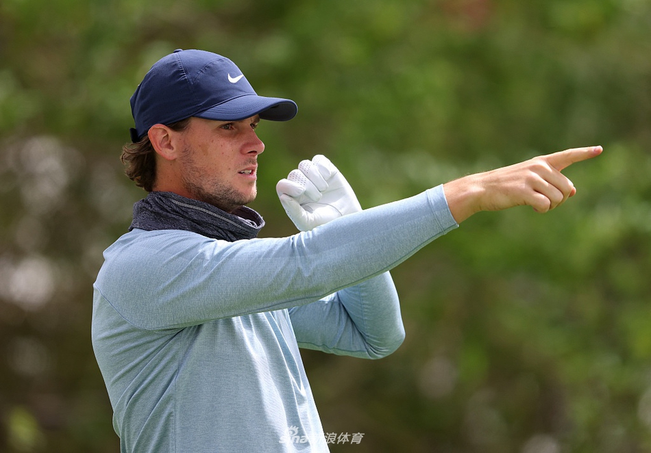 比赛激烈进行中，球员在球道上审慎评估攻果岭路线，广袤的沙漠背景与现代球场形成鲜明对比。