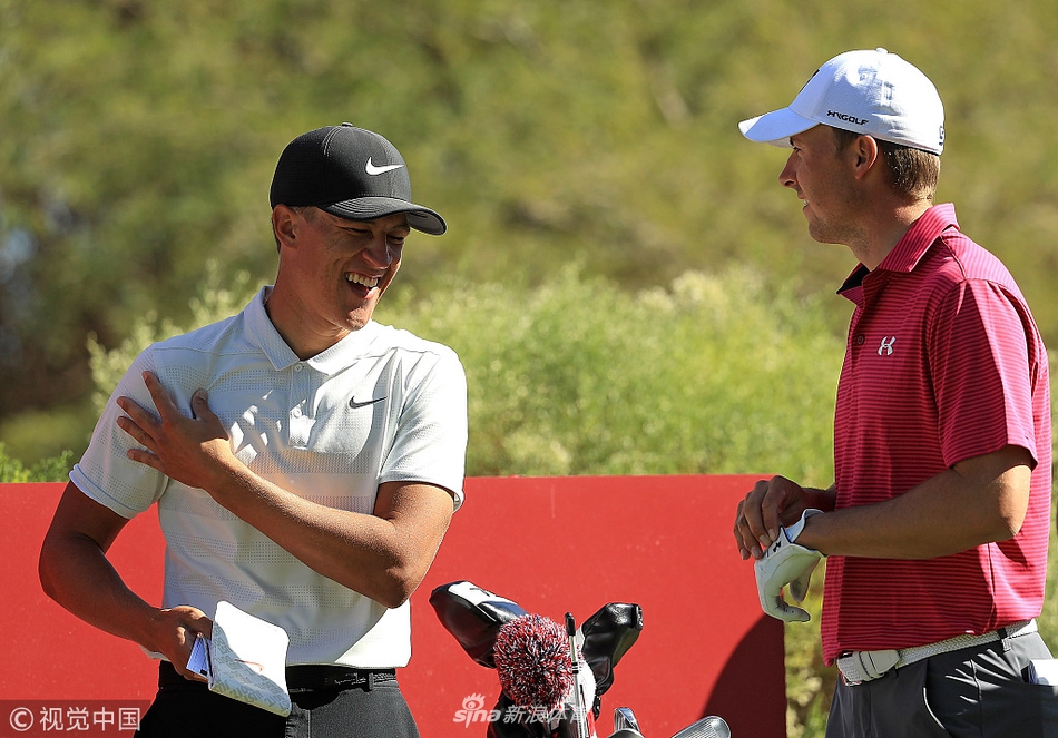 乔丹·斯皮思与同组的卡梅隆·钱普在球道上并肩前行，两人正在交流战术，钱普在本周延续了其火热的手感。