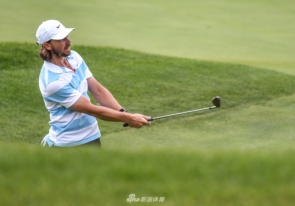 汤米-弗利特伍德在TPC双子城练习果岭边凝神观察，他的标志性长卷发在微风中轻扬。