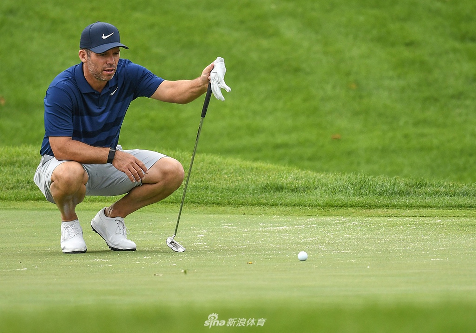 保罗-卡西在球道沙坑中练习救球，专注的眼神锁定在小白球上，沙坑杆划过扬起一道细沙。