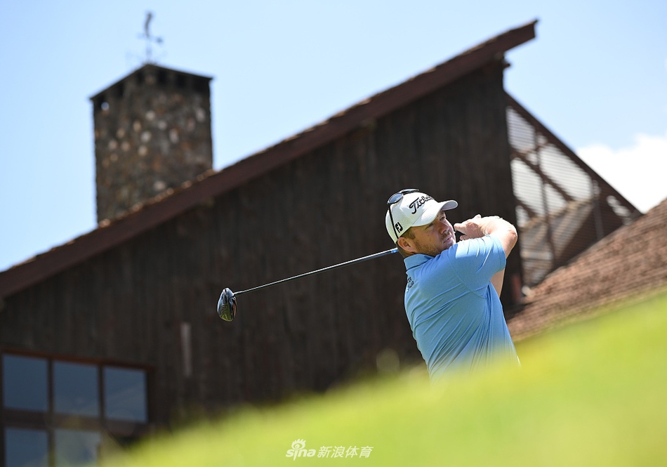 英格兰高尔夫选手加里克·希格在练习场专注地进行铁杆击球训练，身旁散落着一筐练习球。