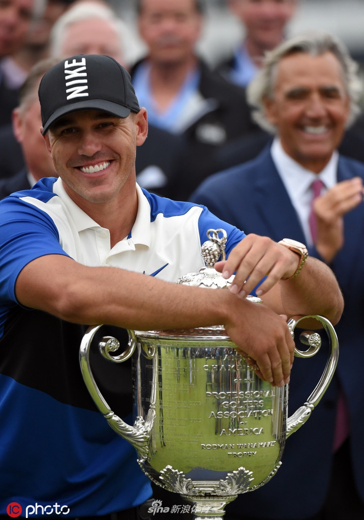 科普卡高举沉重的瓦纳梅克奖杯，阳光照亮奖杯顶端，也映衬着他如释重负的灿烂笑容。