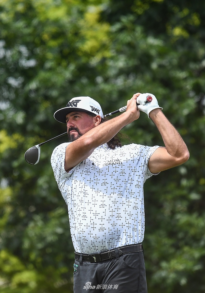 布兰登-格雷斯在练习轮中轻松走过TPC双子城的桥梁，阳光洒在球道上，画面宁静而充满力量感。