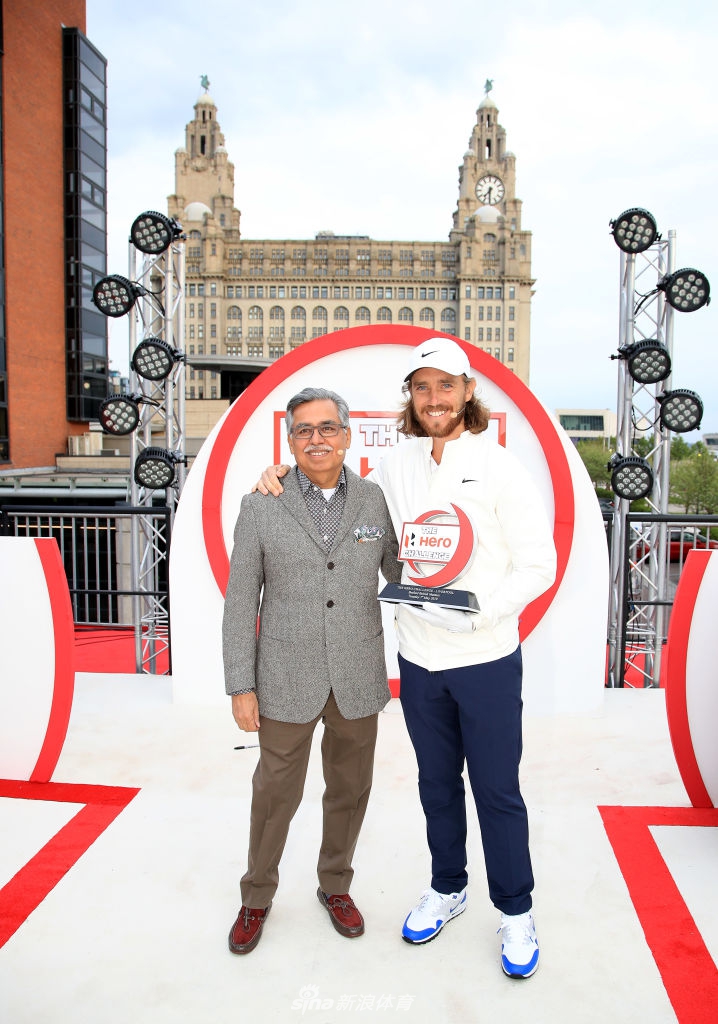 冠军弗利特伍德面带温暖笑容，亲切地将手搭在奖杯上，接受现场的祝贺与欢呼。