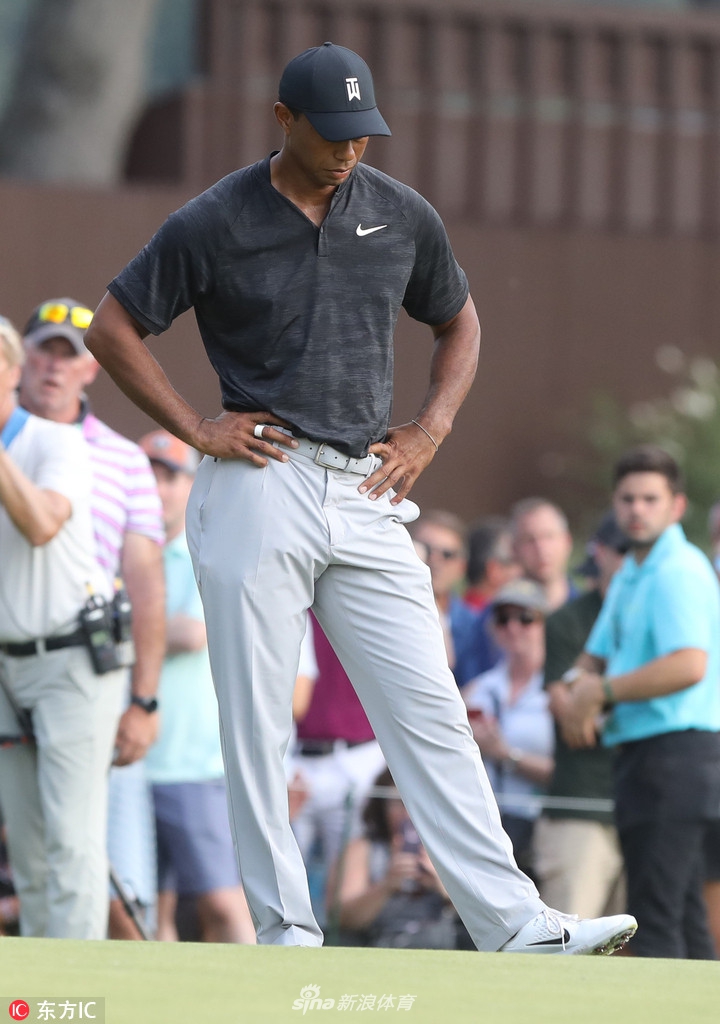 伍兹在果岭边仔细研读推杆线路,眉头微蹙,仿佛在思索如何攻克这令他整日困扰的果岭。