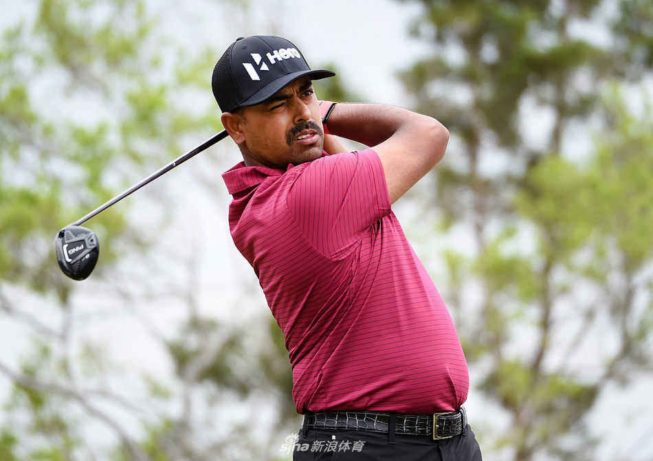 观众聚集在果岭周围屏息观赛，构成一幅色彩斑斓的背景，聚焦于中央球员挑战关键推杆的紧张时刻