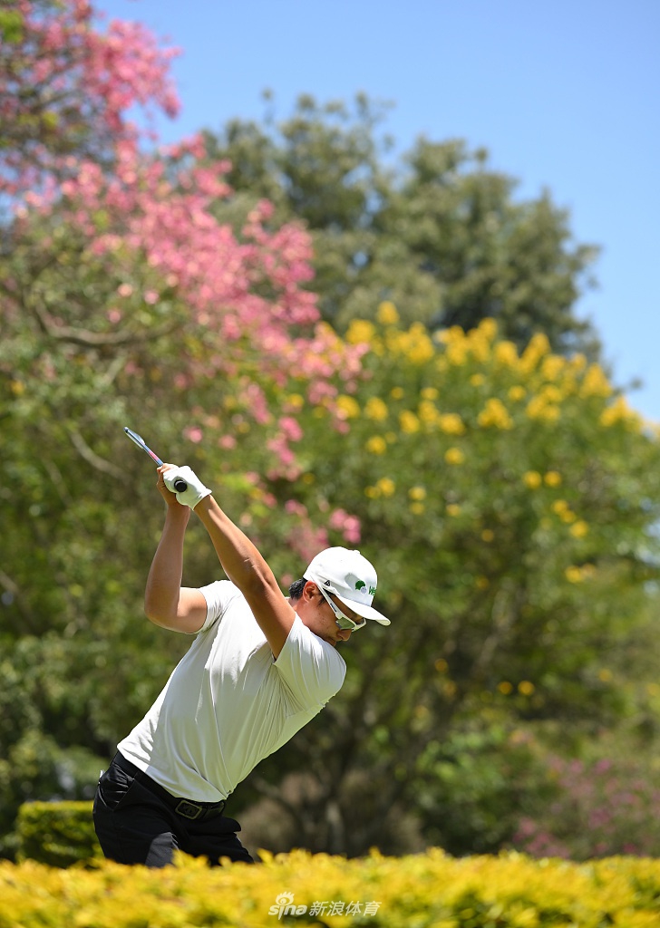 中国高尔夫球星李昊桐在凯伦球场练习果岭边切杆，神情专注，身后是典型的非洲疏林草原景观。