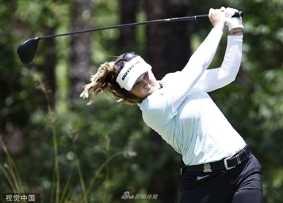 李旻智向全场观众展示冠军奖杯，背景是夕阳下恢弘的俱乐部会所，构成了一幅冠军与历史球场交相辉映的经典画面。