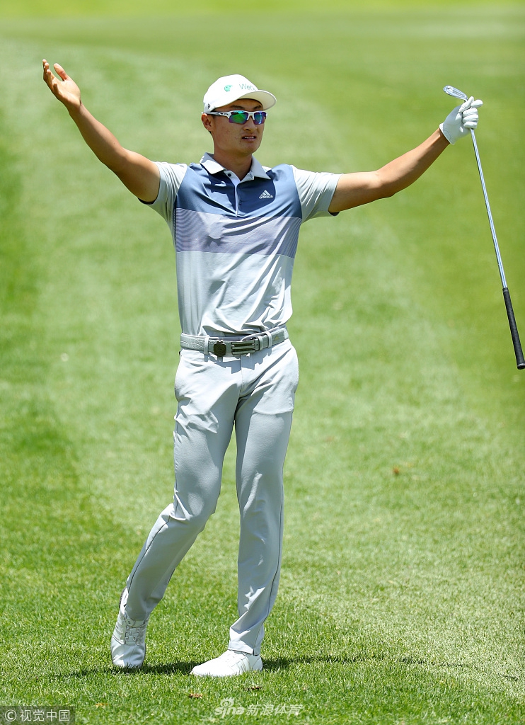 李-维斯特伍德与女友兼球童并肩走过球道,两人相视而笑,默契十足