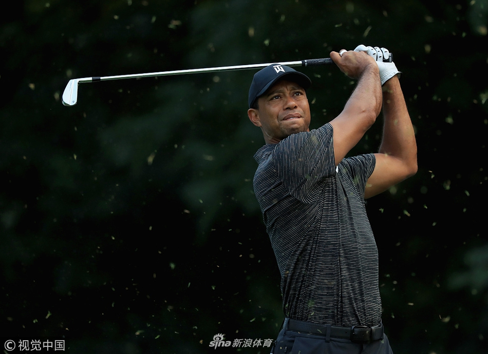 达斯汀约翰逊在练习场专注进行上杆动作,身体舒展充满力量,目光紧盯着远方目标。