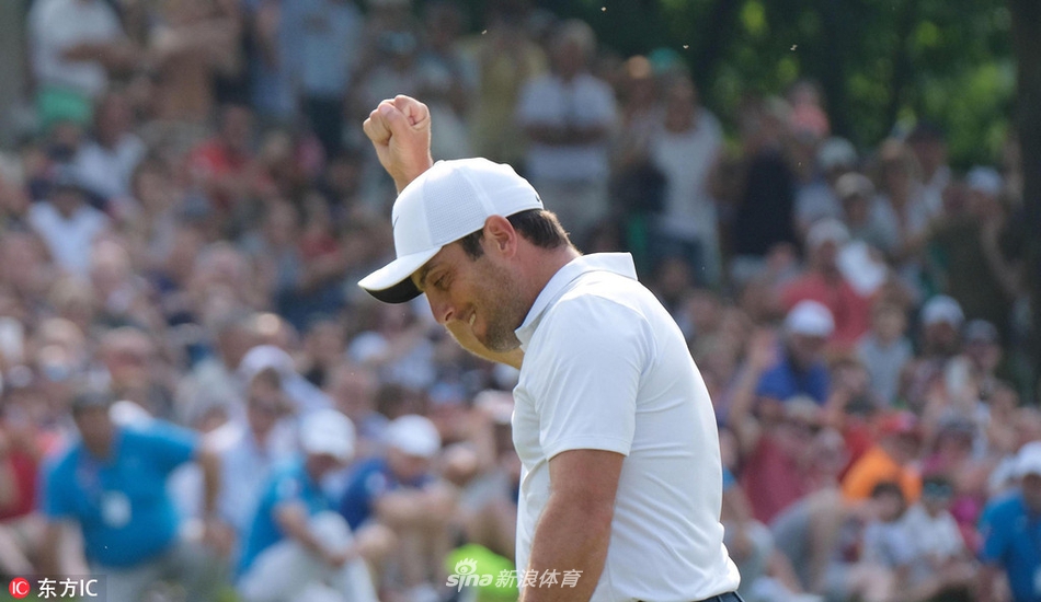 冠军托比约·奥勒森在第十八洞果岭举起冠军奖杯，尽情享受胜利时刻，周围的工作人员与观众为他送上掌声。