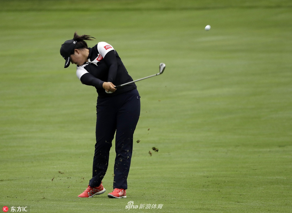 冯珊珊在沙坑中优雅挥杆，沙粒飞扬间尽显救球大师风范