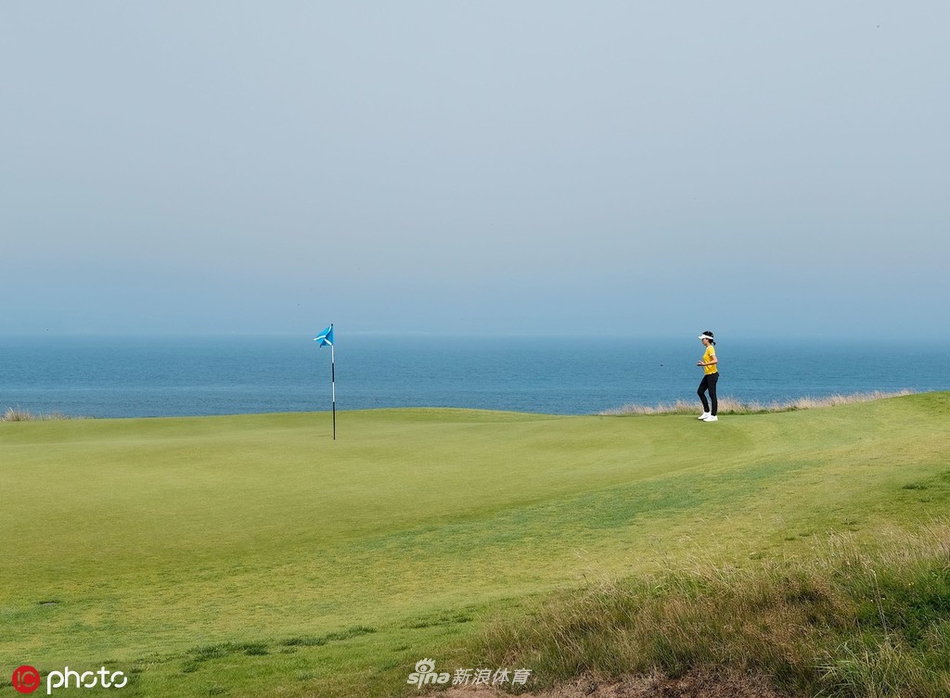 何沐妮在沙坑中救球,沙粒飞扬的瞬间捕捉到了高尔夫运动力量与技巧结合的美感。