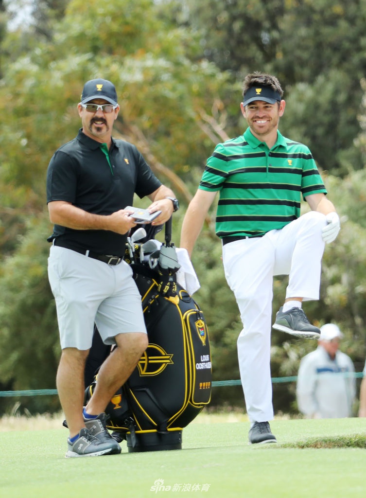 国际队队长厄尼·埃尔斯与队员在练习日深入交流,手指远方分析球道策略,尽显老将的智慧与领袖风范。