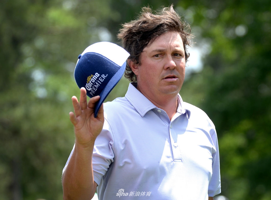 约尔·达门在果岭上仔细研究推杆线路,他紧抿嘴唇,全神贯注于眼前的挑战。