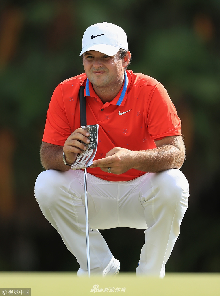 一位球员在沙坑中奋力救球，沙粒飞溅，展现了高尔夫比赛中处理困难球位的瞬间力量感。