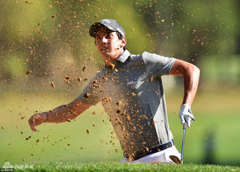 球手在沙坑中陷入困境，正进行艰难救球，沙土飞扬展示击球力度