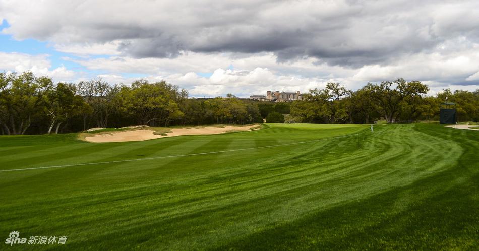 高尔夫球手在沙坑中完成救球，沙粒飞溅的瞬间充满力量感，展现了克服困难的运动精神