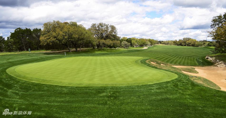 俯瞰视角下的高尔夫球道，蜿蜒穿过树林与湖泊，像一条翠绿色的丝带铺展在大地上，展现球场的整体规划之美