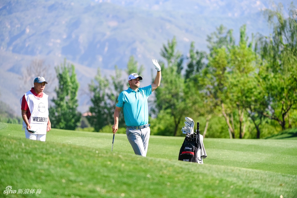 奥地利高尔夫球手贝恩德·维斯伯格在果岭边手搭凉棚，全神贯注地观察远处球洞的方位与草地起伏。